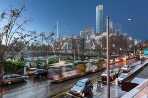 a busy city street with cars and a bus at A Chic & Comfy 2BR Apt Near Federation Square in Melbourne