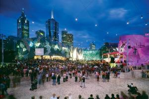a large crowd of people in a city at night at A Chic & Comfy 2BR Apt Near Federation Square in Melbourne