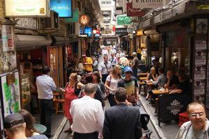 a crowd of people walking down a street in a market at A Chic & Comfy 2BR Apt Near Federation Square in Melbourne