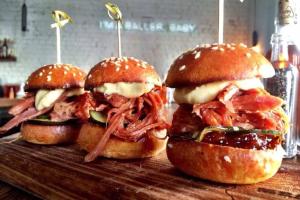 three pulled pork sandwiches sitting on a cutting board at A Chic & Comfy 2BR Apt Near Federation Square in Melbourne