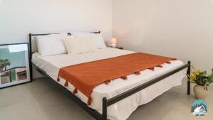 a bedroom with a large bed with a orange blanket at Aircabin - Cobbitty - Lovely - 5 Beds House in Cobbitty