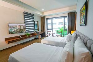 a hotel room with two beds and a couch at Hoang Son Peace Hotel in Ninh Binh