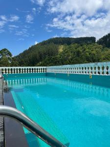 a large swimming pool with a mountain in the background at Bellwood Hills Resort & Spa in Kandy