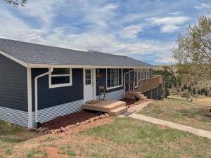 a home with a blue house with a porch at Stay in a Historic Gold Mine Town w/Mountain Views in Victor