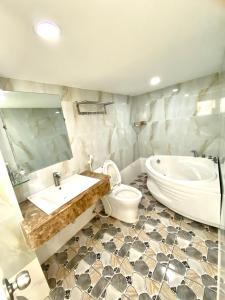 La salle de bains est pourvue d'une baignoire, de toilettes et d'un lavabo. dans l'établissement Nhat Hoang Hotel, à Hô-Chi-Minh-Ville