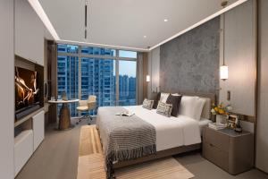 a bedroom with a large bed and a tv at Ascott Pazhou Guangzhou in Guangzhou