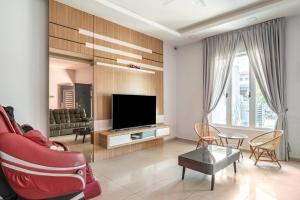 un soggiorno con divano rosso e TV di Venus.28 Melaka Homestay ad Ayer Keroh
