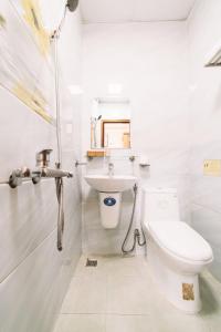 Baño blanco con aseo y lavamanos en KHÁCH SẠN TUẤN KIỆT en Dalat