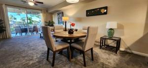 a dining room with a table and chairs and a living room at Waikoloa Beach Villas F22 condo in Waikoloa