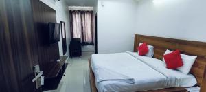 a bedroom with a bed with red pillows at The Grace Residency in Gurgaon