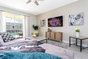 een woonkamer met een bank en een tv bij Home away from Home with Private Pool CHG103 in Kissimmee