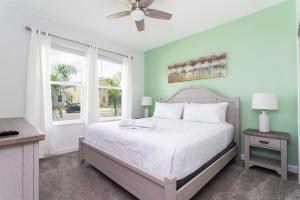 een slaapkamer met een wit bed en een raam bij Home away from Home with Private Pool CHG103 in Kissimmee
