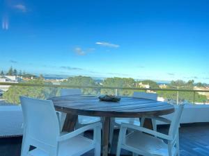 d'une table en bois et de 2 chaises blanches sur un balcon. dans l'établissement Albufeira Beach Apartment, à Guia