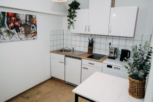 a white kitchen with white cabinets and a table at Fewo-Rathaus in Kempten