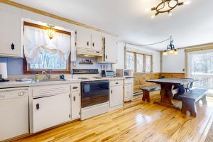 una cucina con armadietti bianchi e pavimenti in legno di Little Bend Haven a Wilmington