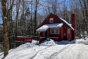 una cabina rossa nel bosco con neve sul terreno di Little Bend Haven a Wilmington
