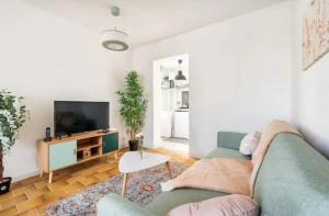 ein Wohnzimmer mit einem grünen Sofa und einem TV in der Unterkunft Teric in Le Pin