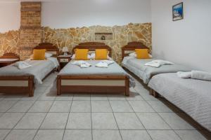 Pokój z 3 łóżkami i żółtymi poduszkami w obiekcie Pension Stella w mieście Karterados