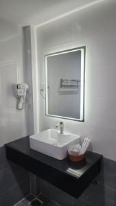 een badkamer met een witte wastafel en een spiegel bij HOTEL SONG TIÊN in Trà Vinh