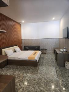 a bedroom with a large bed and a desk and avertisement at HOTEL SONG TIÊN in Trà Vinh
