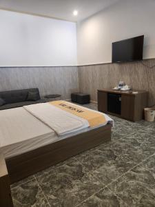 1 dormitorio con 1 cama y TV de pantalla plana en HOTEL SONG TIÊN en Trà Vinh