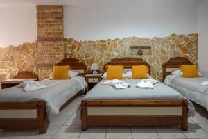 Pokój z 3 łóżkami i żółtymi poduszkami w obiekcie Pension Stella w mieście Karterados +37 zdjęć