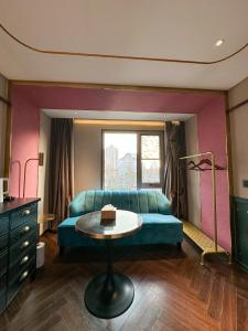 a living room with a blue couch and a table at Xinyu Hotel - Shanghai Jiao Tong University Xinhua Road in Shanghai