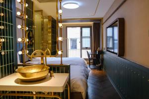 a bathroom with a sink and a bed with a mirror at Xinyu Hotel - Shanghai Jiao Tong University Xinhua Road in Shanghai