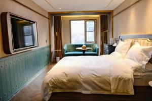 a hotel room with a bed and a tv at Xinyu Hotel - Shanghai Jiao Tong University Xinhua Road in Shanghai