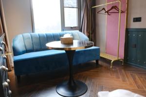 a blue couch and a table with a box on it at Xinyu Hotel - Shanghai Jiao Tong University Xinhua Road in Shanghai
