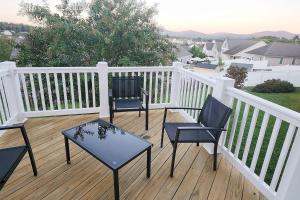 3 Stühle und ein Tisch auf einer Terrasse in der Unterkunft Modern 5 Bedroom Home, 6 miles from Skyline Drive in Waynesboro