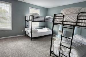 Zimmer mit 3 Etagenbetten in einem Zimmer mit Fenster in der Unterkunft Modern 5 Bedroom Home, 6 miles from Skyline Drive in Waynesboro