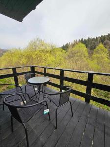 a patio with two chairs and a table on a deck at Симфонія біля річки Чан in Skole +16 photos