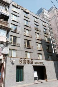 un grand bâtiment avec des écritures sur son côté dans l'établissement Xinyu Hotel - Shanghai Jiao Tong University Xinhua Road, à Shanghai