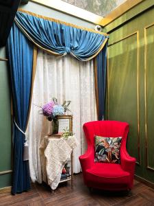 a red chair sitting in front of a curtain at Xinyu Hotel - Shanghai Jiao Tong University Xinhua Road in Shanghai