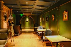 a restaurant with green walls and tables and chairs at Xinyu Hotel - Shanghai Jiao Tong University Xinhua Road in Shanghai