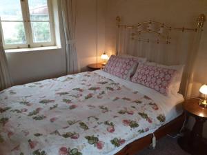 a bedroom with a large bed with a floral blanket at Fernbrook Cottage in Marrangaroo