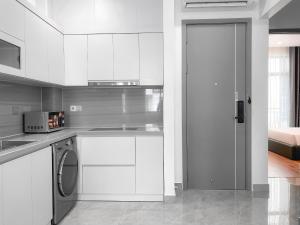 eine Küche mit weißen Schränken und einer Waschmaschine in der Unterkunft Metahome Apartment HOT Độc Đáo Nhất Vinhome Marina in Haiphong