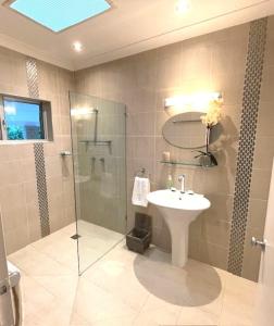 a bathroom with a glass shower and a sink at Aquatica - Luxe Holiday Home in Palm Cove
