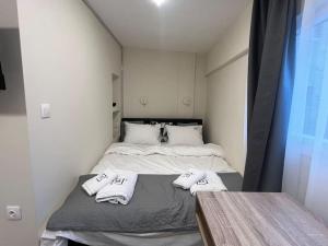 Un pequeño dormitorio con una cama con toallas. en Odyssey Apt 3, en Tesalónica