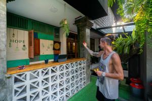 een man die voor een bar staat bij Interconnection Hostel in Kuta