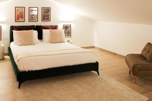 sypialnia z dużym łóżkiem i krzesłem w obiekcie Sorelle Costa apartments w mieście Caserta