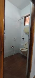 a small bathroom with a toilet and a window at cg residency in Pondicherry