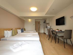 a hotel room with two beds and a table at ESLEAD HOTEL Namba South Ⅰ in Osaka