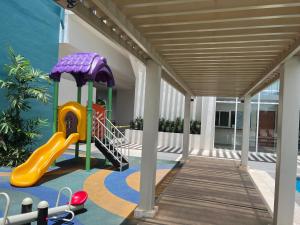 a play area with a slide and a playground at Comfy unit with fast wifi along Lacson St. in Bacolod