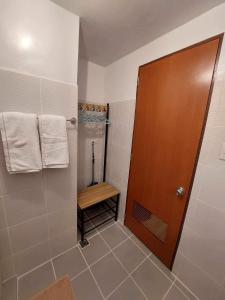 a bathroom with a shower and a wooden door at Comfy unit with fast wifi along Lacson St. in Bacolod
