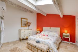 een slaapkamer met rode muren en een bed met 2 poeven bij Le love baroque in Lézignan-la-Cèbe