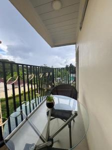 a glass table and a chair on a balcony at Cozy Kalundu Apartment in Lusaka