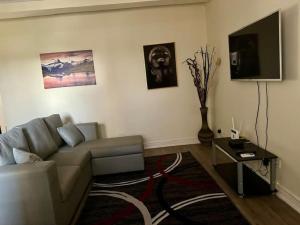 a living room with a couch and a tv at Cozy Kalundu Apartment in Lusaka