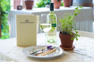 einen Tisch mit einer Flasche Wein, einem Teller und einem Glas Wein in der Unterkunft GRÜNER HEINRICH - Bett&Frühstück in Oberaichwald